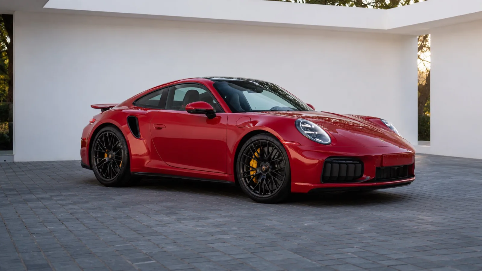 Rode Porsche 911 Turbo S voor een witte gevel