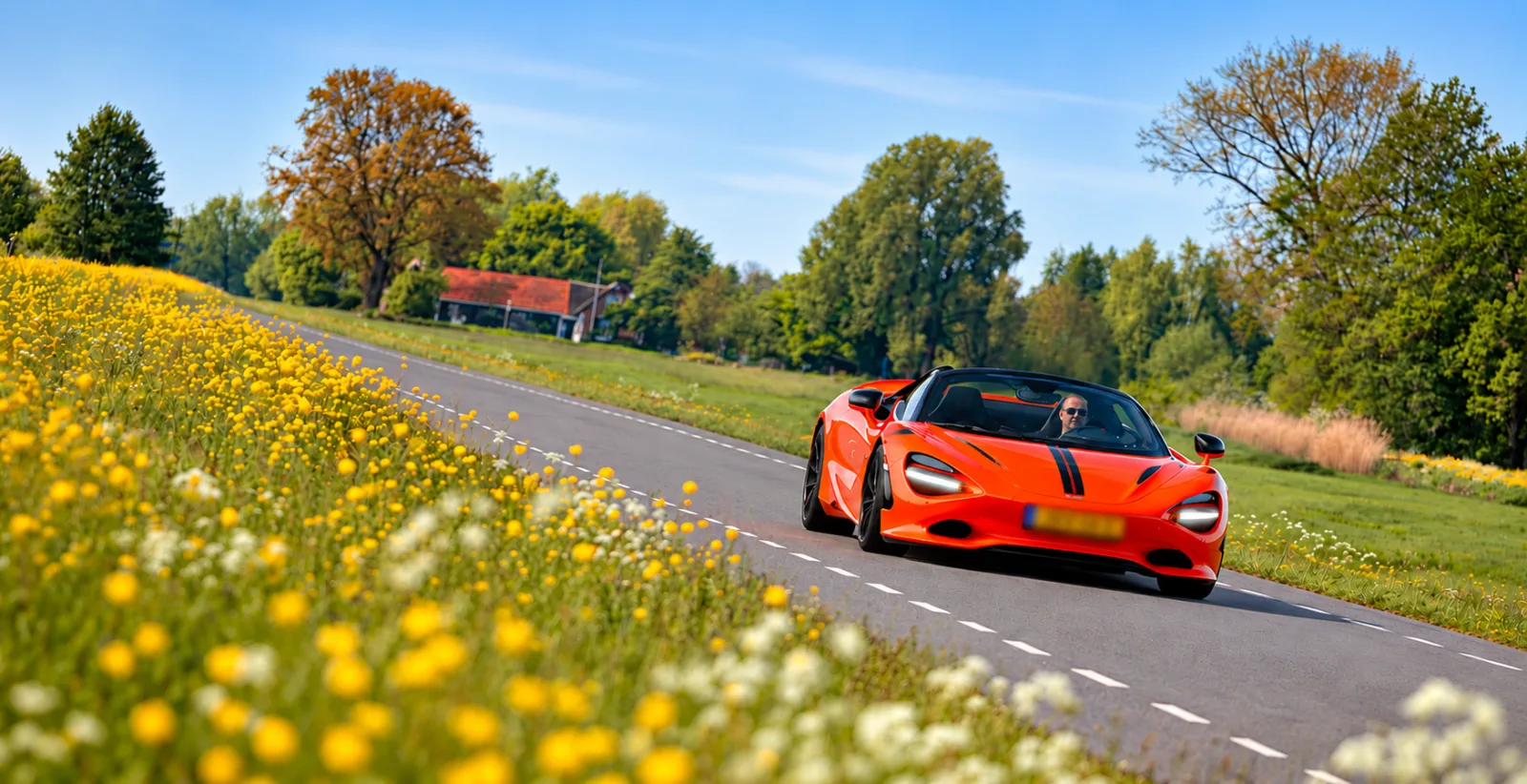 Oranje supercar Mclaren 750s door mooi landschap